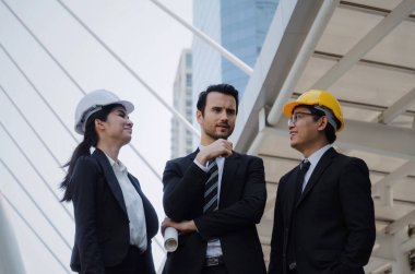 Grup iş ya da mühendis kadın ve yeni proje, başarılı konsepti başlangıç planlama adam kask ve binaya planlama ve modern şehir, çalışmalarını kontrol planı