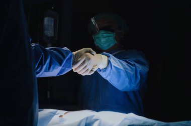 Kurtarma hasta hastane, acil durum, cerrahi, Medikal teknoloji, Sağlık Kanser ve hastalık tedavi kavramı operasyon odasında için cerrahlar iş sonra asistan elini sıkarken doktor