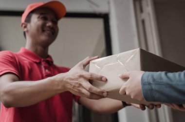 evde kuryeden parsel posta kutusu alan kadın müşteri ile gülümseyen kırmızı üniformalı genç teslimat servisi adam, kargo nakliye, ekspres teslimat hizmeti, online alışveriş ve lojistik konsepti