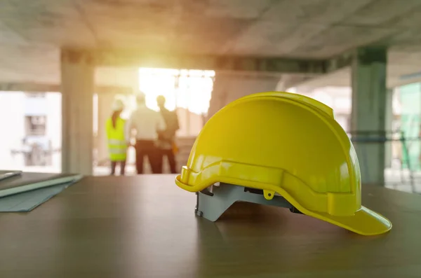 建設現場の背景 エンジニアリング 請負業者の概念で新しいプロジェクト契約をチェックする建設労働者チームのエンジニアや検査官と職場の机の上に黄色の安全ヘルメット — ストック写真