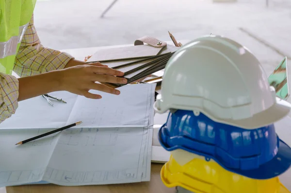 プロの建築家 エンジニア インテリアデザインの手は 建設現場 請負業者 インテリア 建設とエンジニアリングの概念でオフィスセンターの職場の机の上の安全ヘルメットで作業 — ストック写真