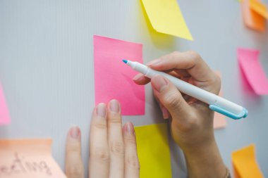 İş kadını el yazısı ve renkli kağıtlar ev ofisinin arka planı üzerine yapışkan not kağıdı, iş toplantısı, beyin fırtınası, yaratıcı, dijital çevrimiçi pazarlama, finansal konsept