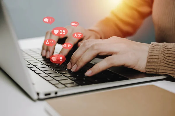 hand of woman working with laptop computer and play social network with virtual icon on desk at home office, online marketing, digital technology, social media, internet, networking connection concept