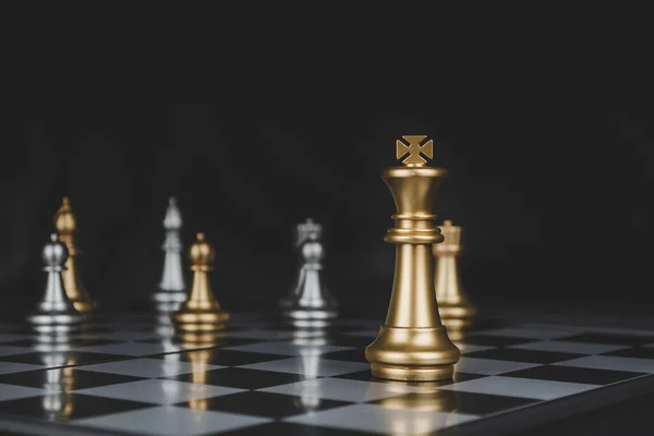estratégia de negócio. rei dourado com peça de xadrez de prata na