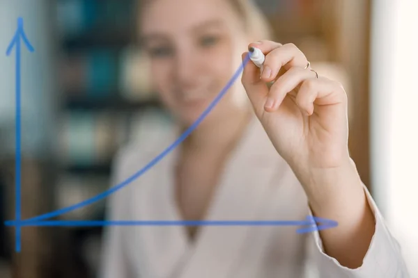 Kız cama bir işaret çiziyor.