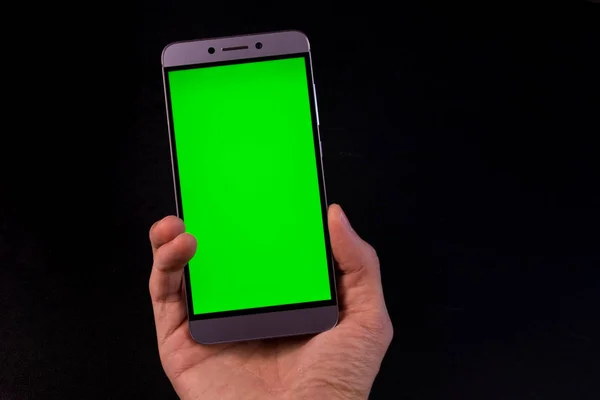 Elinde yeşil ekran, siyah arkaplan olan akıllı telefon.
