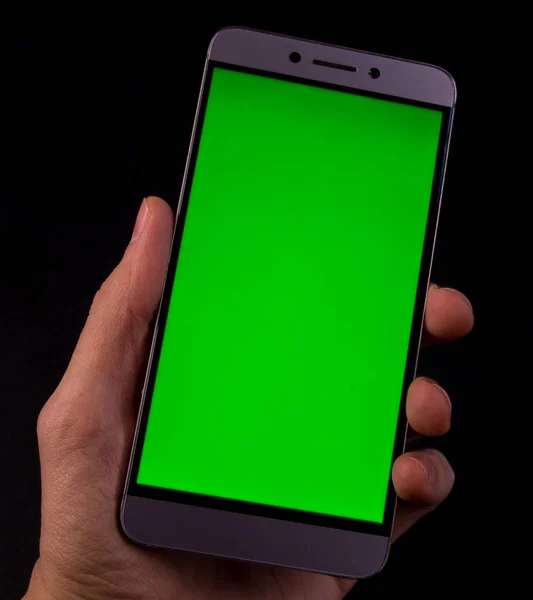 Elinde yeşil ekran, siyah arkaplan olan akıllı telefon.