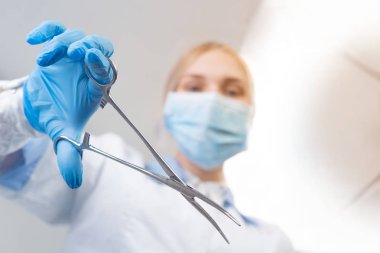 Kız. Doktor bir ameliyat yapıyor. Hastanın tarafından ya da altından bakıyor.