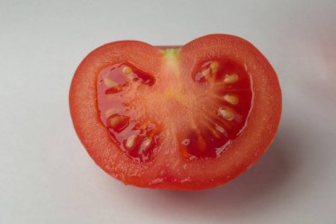 Beyaz arka planda yarım domates veya dilimlenmiş domates.
