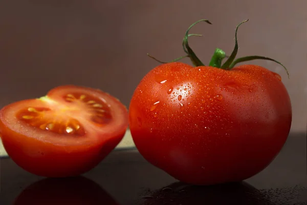 Bütün domates ve yarım domates cam bir masada.