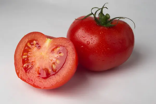 Beyaz arka planda domates ve yarım domates.