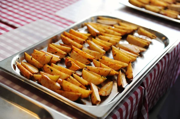 Cales de pommes de terre sur une plaque à pâtisserie métallique Photo De Stock