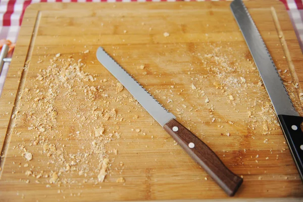 Deux grands couteaux à pain sur une planche à découper Image En Vente