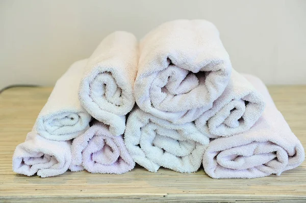 Pilha de toalhas de banho no fundo de madeira leve — Fotografia de Stock