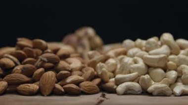 Ahşap bir masa üzerine siyah izole karışık Kuruyemiş yığınları