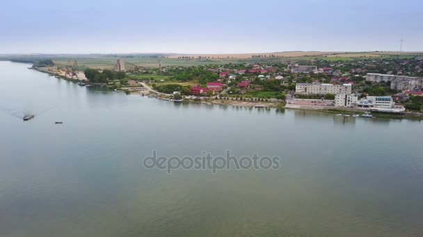 Flygfoto över en liten by och Donau innan flyter i havet — Stockvideo