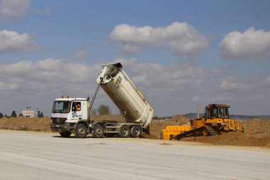 Damperli kamyon boşaltma toprak pist inşaat sitesinde