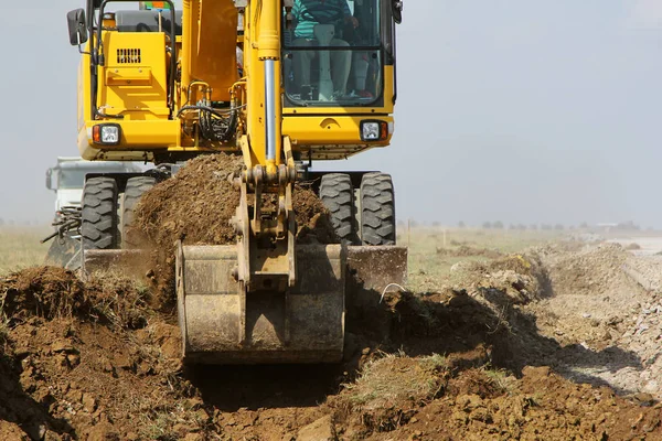 Excavadora de orugas trabajando en un sitio de construcción de pista — Foto de Stock