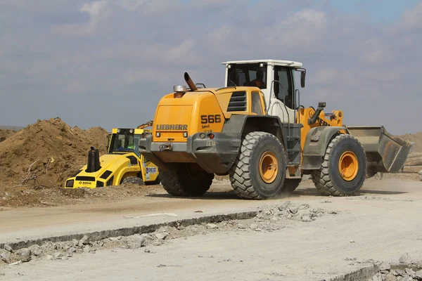 Heavy construction equipment working on a runway construction site