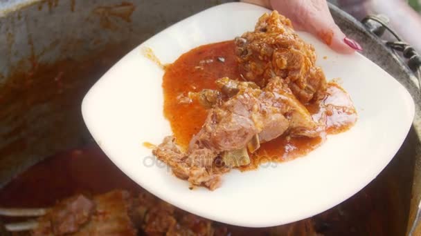 Dušené jehněčí vařené ve velkém hrnci kovu a servírujeme s polentou — Stock video