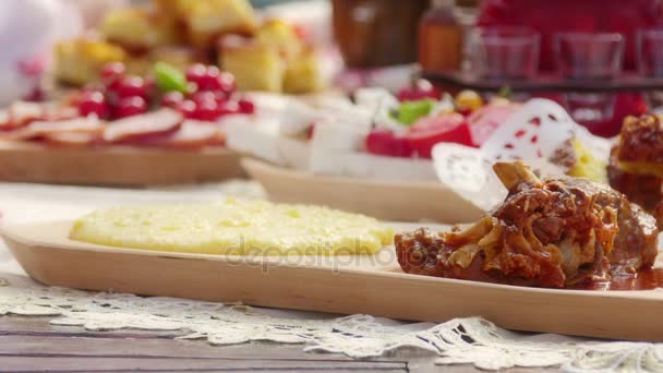 Polenta und Lammeintopf mit geriebenem Käse auf einem Holzbrett — Stockvideo