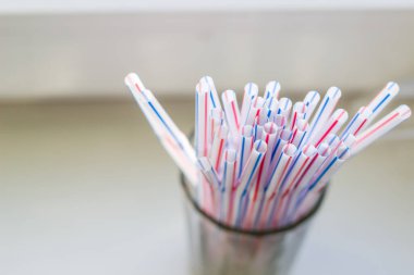Parlak bir günde bardaktaki kokteyller için tek kullanımlık plastik tüpler. Çevre dostu değil..