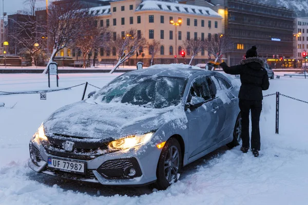 Kvinna rengöring hennes bil från snön. — Stockfoto