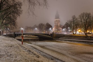 Gece kış zamanında Turku Katedrali ve Aura nehrinin görünümü.