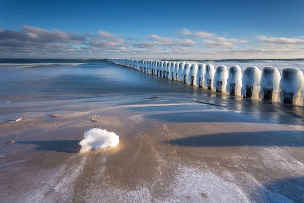 Paisagem de inverno no mar. Linha de quebra-mares de madeira congelada no mar Báltico . — Fotografia de Stock