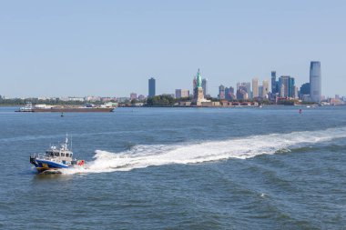 New York polisi tekne Doğu Nehri devriye. Arka plan Özgürlük Anıtı ve gökdelenler New Jersey.