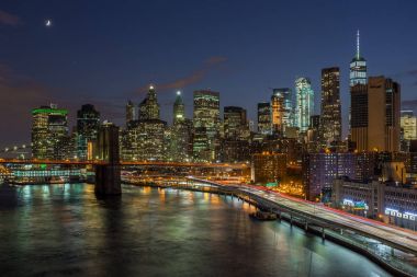 new York'ta gece aşağı manhattan siluetinin ile Brooklyn Köprüsü.