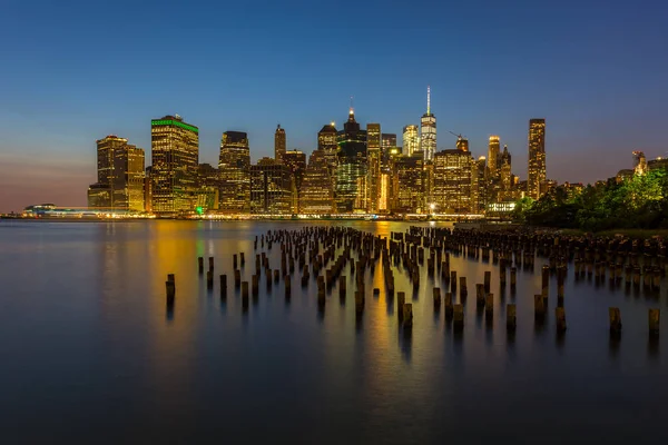 Vista de rascacielos en el bajo Manhattan desde el horizonte de Brooklyn en la ciudad de Nueva York por la noche . — Foto de Stock