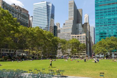 İnsanlar yaz, güneşli günde Bryant Park'ta rahatlatıcı.