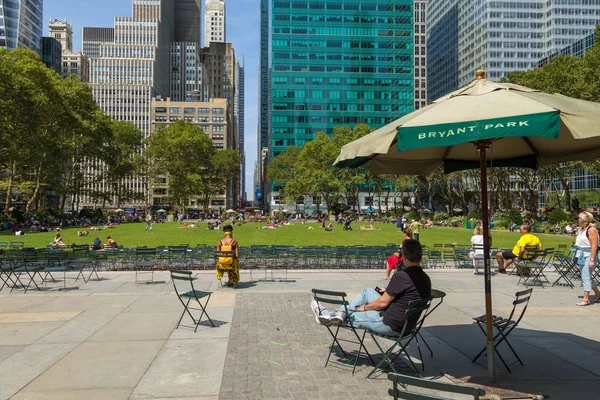 İnsanlar yaz, güneşli günde Bryant Park'ta rahatlatıcı.