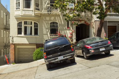 San Francisco, Kaliforniya, ABD - 07 Haziran 2015: Lombard Caddesi 'nin ünlü dik köşesindeki şık ön cephe ve park edilmiş arabalar.