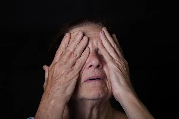 Портрет пожилой женщины. Закрывает глаза руками — стоковое фото