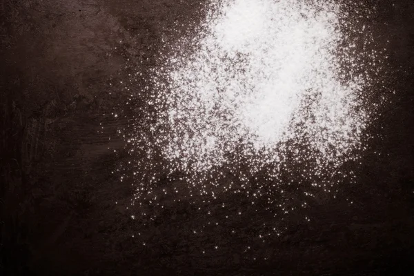 Flour spilling on black metal background. Toned — Stock Photo, Image