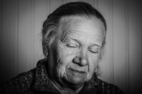 Retrato de uma mulher idosa sobre um fundo claro. Tonificado — Fotografia de Stock