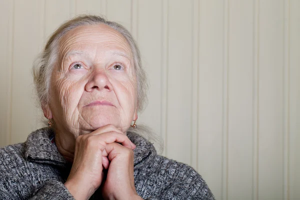 Portrait d'une femme âgée avec les mains près du visage sur un bac léger — Photo