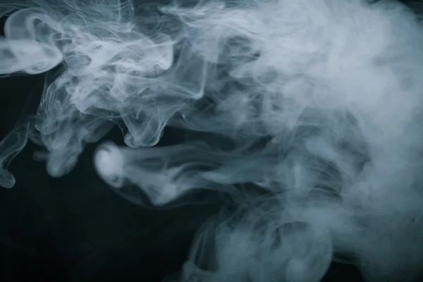 Bir siyah arka plan üzerinde duman bulutu. Seçici odak. Tonda