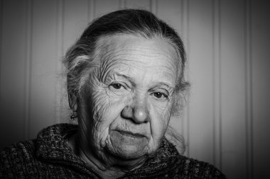 Hafif bir arka plan üzerinde yaşlı bir kadın portresi. Tonda