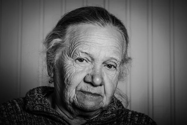 Retrato de uma mulher idosa sobre um fundo claro. Tonificado — Fotografia de Stock