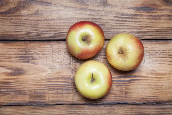 Gul-röd säsongens äpplen på bakgrunden av brända skivor — Stockfoto