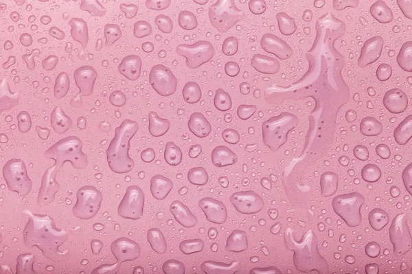 Druppels water op een gekleurde achtergrond. Roze. Selectieve aandacht. Ton — Stockfoto