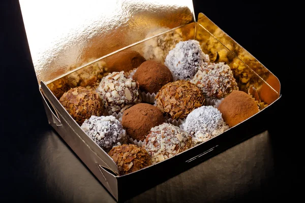 Set of different kinds of homemade chocolate truffles in a golde