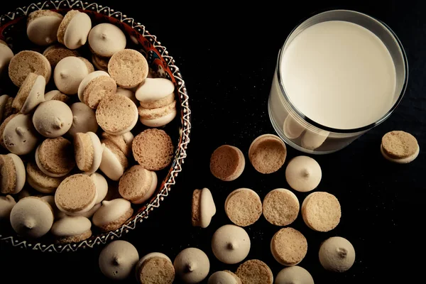 Small cookies in the Turkish bowl and glass of milk on a black t — Stock Photo, Image