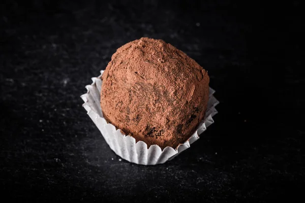 Un caramelo de chocolate en un fondo de pizarra. Tonificado — Foto de Stock