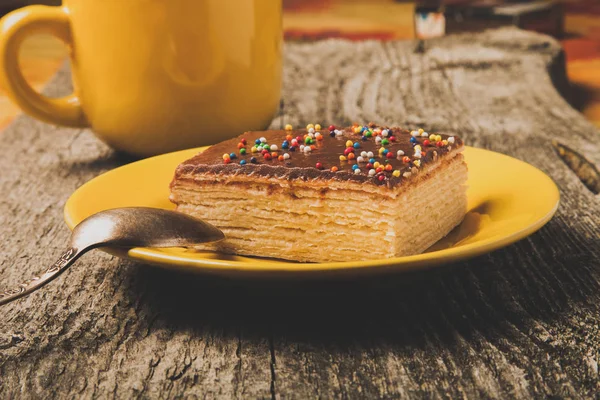 Νόστιμα Βάφλα σοκολάτα κέικ και κίτρινο φλιτζάνι του καφέ σε παλιό ξύλο — Φωτογραφία Αρχείου