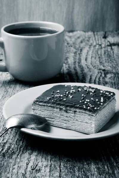 Gâteau aux gaufres au chocolat savoureux et tasse de café jaune sur vieux bois — Photo