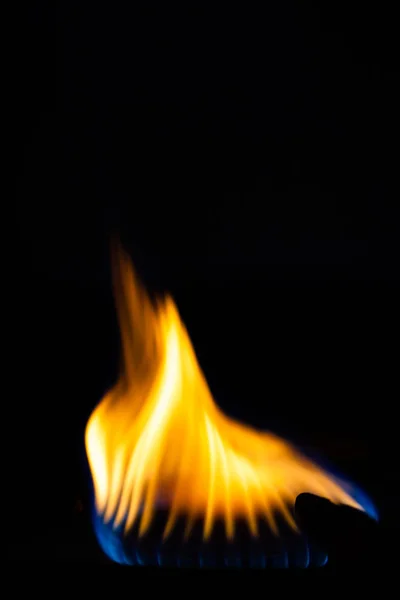 Gas burns on the burner on the stove in the dark. Selective focu — Stock Photo, Image